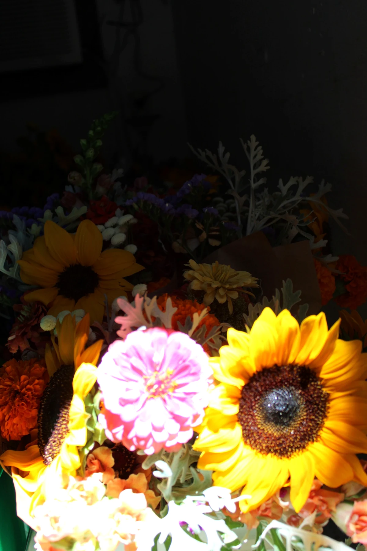 HappyDay Farms bouquets in low light with sunflowers, zinnias, marigolds and mixed seasonal flowers